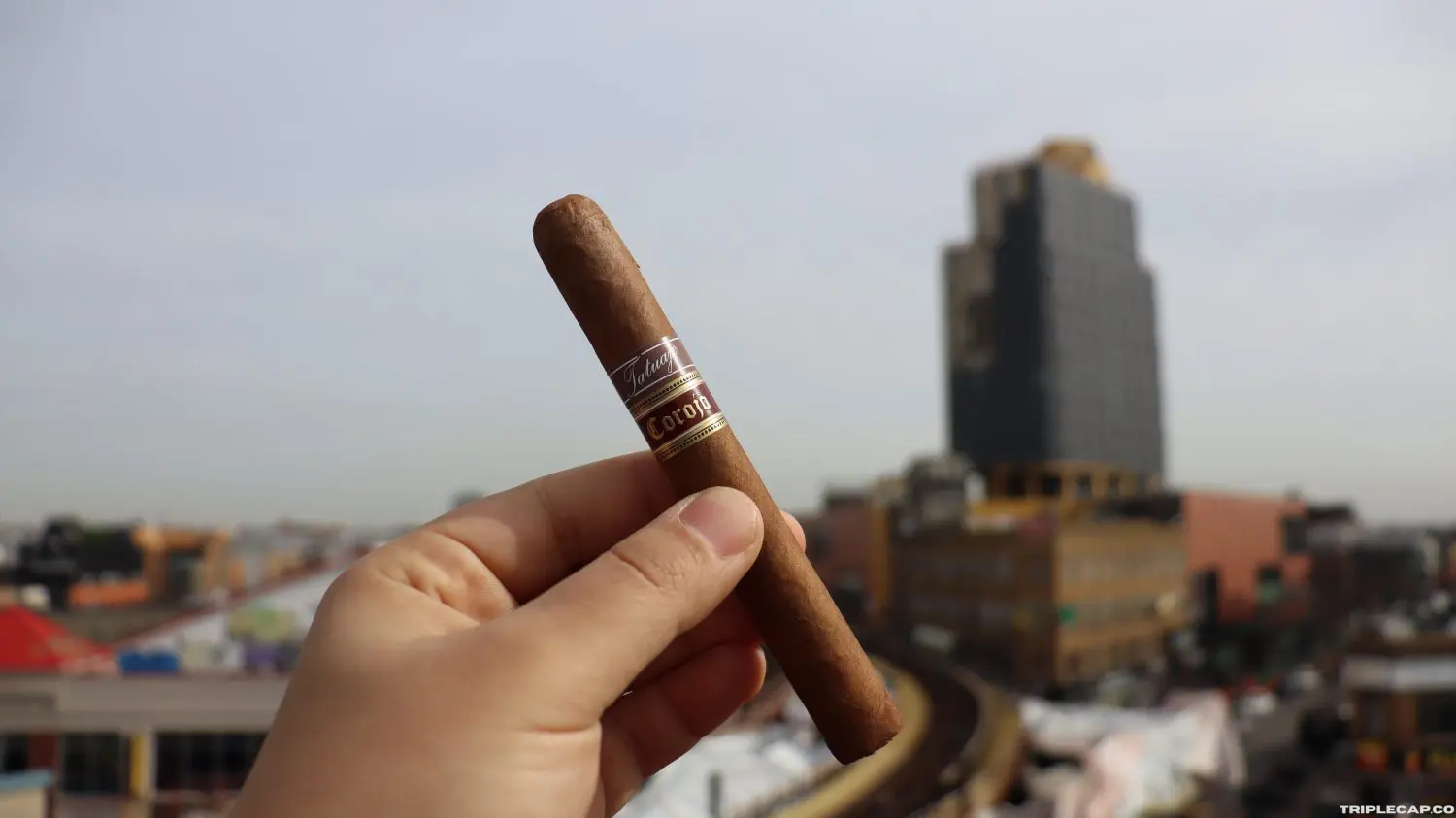 Tatuaje 7th Corojo cigar prelight showing oily Nicaraguan Corojo wrapper with visible tooth and triple cap